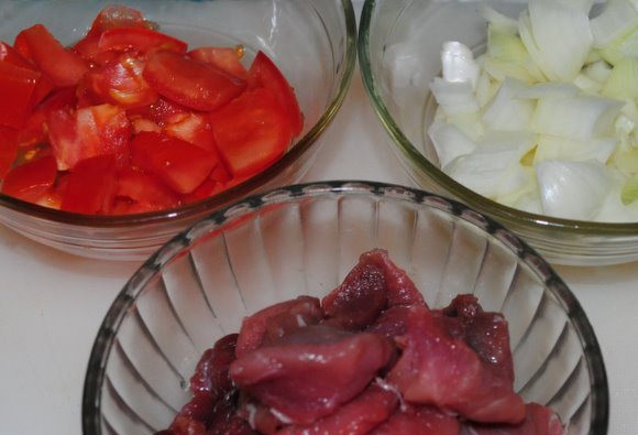 1. Этап. Венгерский гуляш из говядины: Говядину, лук и помидоры порежьте на куски, чеснок мелко порубите.