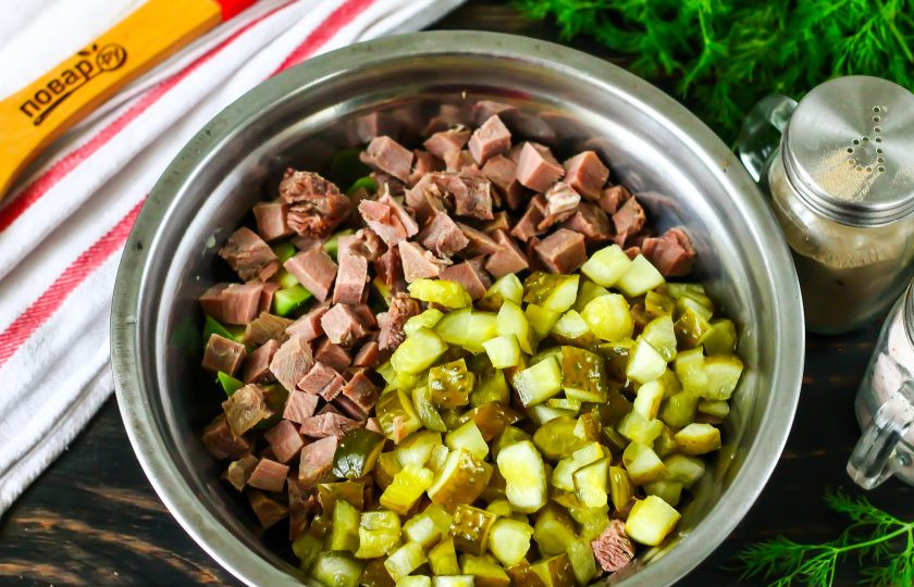 1. Этап. Кето-оливье: Нарежьте такими же кубиками отварной язык и соленые огурцы. Огуречную нарезку оставьте на 5 минут, чтобы она выделила сок, который затем слейте. Нарезку добавьте в емкость.