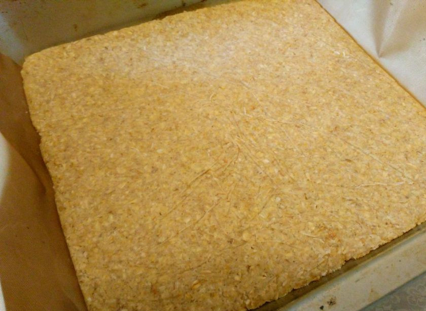 1. Этап. Геркулесовые пирожные: Выньте застывшее тесто из морозилки и аккуратно освободите от пакета, перенесите пласт на противень.