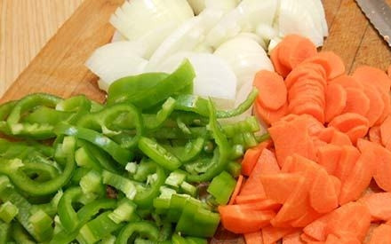 1. Этап. Ребрышки ягненка, тушенные с картошкой: Очищенную морковь и лук нарежьте кусочками вместе с перцем.