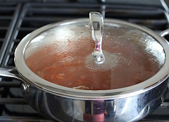 1. Этап. Ракушки с фаршем в томатном соусе: 5. Накройте сковороду крышкой, включите максимальный огонь, доведите до кипения, затем уменьшите огонь и готовьте 10-12 минут.