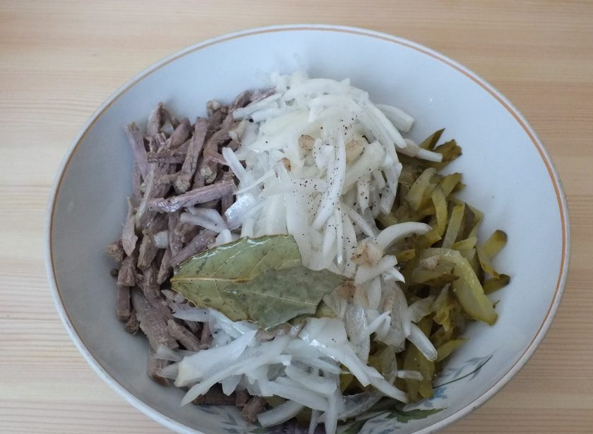 1. Этап. Салат Шахтерский с солеными огурцами: Маслом полейте продукты в салатнике. Лавровый лист удалите.