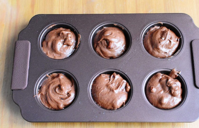 1. Этап. Капкейки с гранатом: Разложите тесто по формочкам.