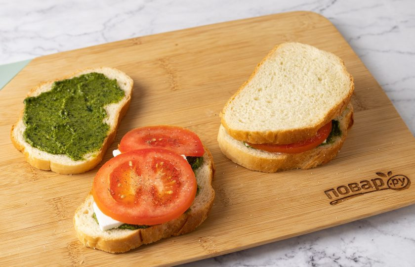 1. Этап. Сэндвич Капрезе: Сверху положите помидор. Посолите и поперчите. Накройте второй половинкой.