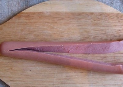 1. Этап. Яичница в сосиске сердечком: Первым делом мы аккуратно разрезаем сосиску вдоль, но не до конце, а оставляем сверху 1, сантиметра целым.