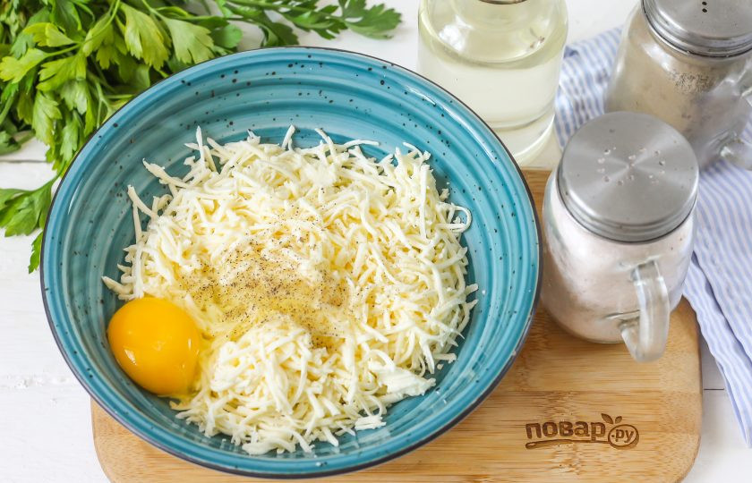 1. Этап. Запеченные перцы с фетой: Фету натрите на терке с мелкими ячейками в глубокую емкость. Попробуйте сыр на вкус, при необходимости присолите. Вбейте туда же куриное яйцо и все перемешайте.