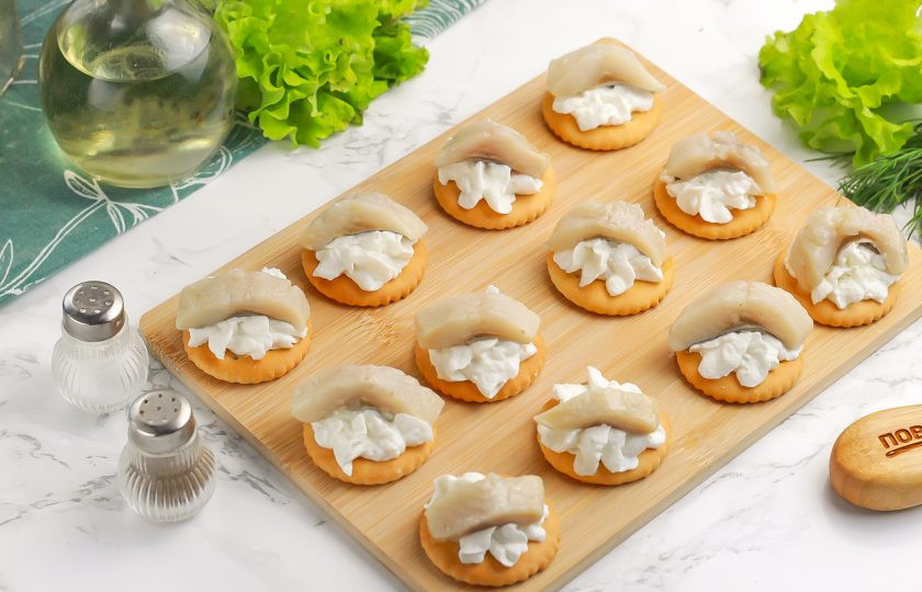 1. Этап. Крекеры закусочные: Выложите по ломтику слабосоленой сельди. По желанию можете заменить ее слабосоленой красной рыбой.