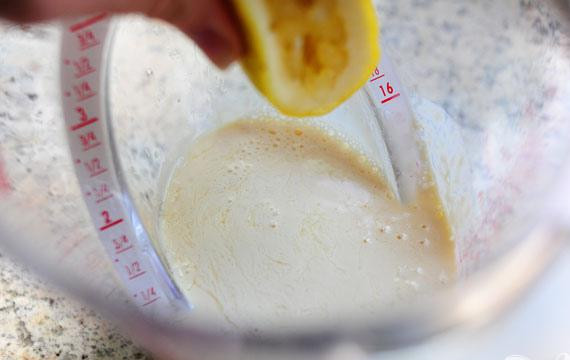 1. Этап. Лимонно-черничные оладьи: 2. В отдельной миске смешать сгущенное молоко, сок 1 лимона (или больше, если лимон не очень сочный) и цедру лимона. Дать смеси постоять в течение 5 минут, затем добавить яйцо, соль и растопленное сливочное масло. Тщательно перемешать массу.