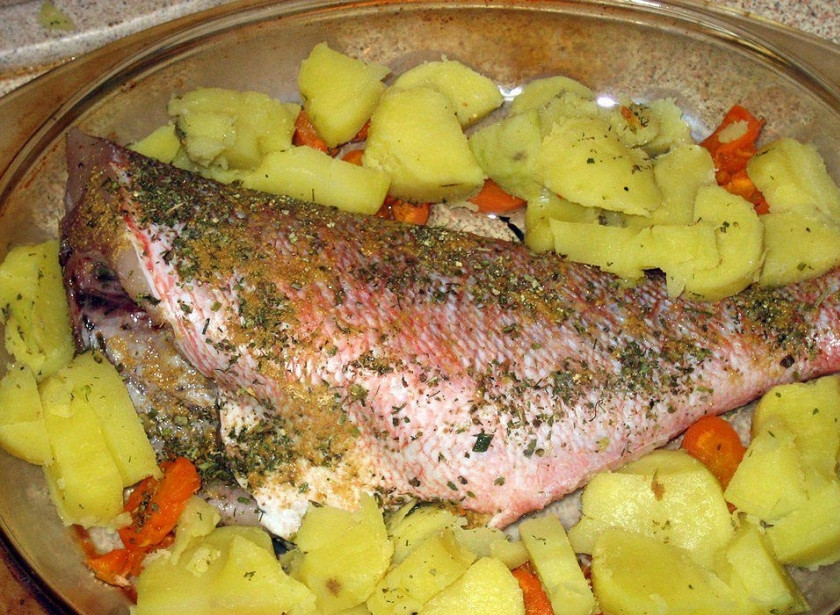 1. Этап. Морской окунь запеченный: Посуду для выпекания смазываем оливковым маслом, выкладываем овощи и окуня. Посыпаем приправами.