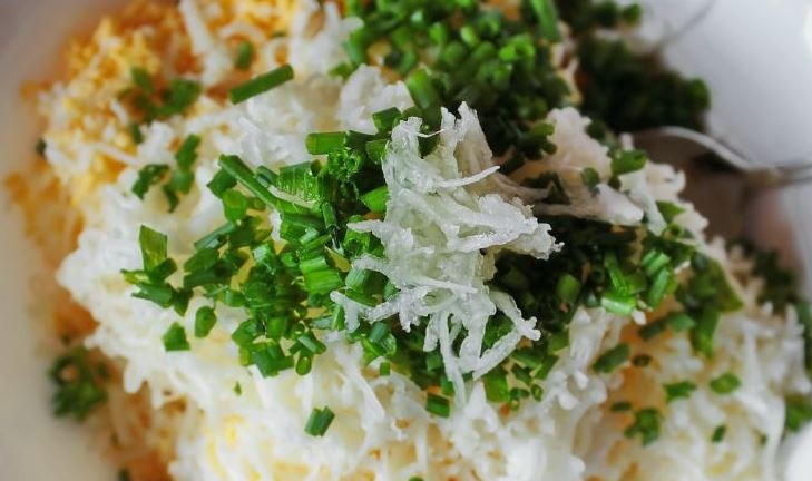 1. Этап. Салат с копченой колбасой и сыром: Отварите яйца вкрутую, обдайте ледяной водой и очистите. Авокадо вымойте и обсушите. Удалите кожицу и косточку. Натрите на терке яйца и авокадо. Очистите и мелко порубите шнитт-лук и чеснок. Смешайте все ингредиенты, добавьте хрен, лимонный сок и соль.