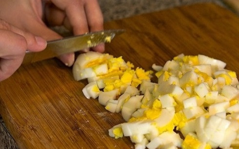 1. Этап. Салат Весенний с крабовыми палочками: Сварим вкрутую яйца и очистим, нарежем кубиками среднего размера.