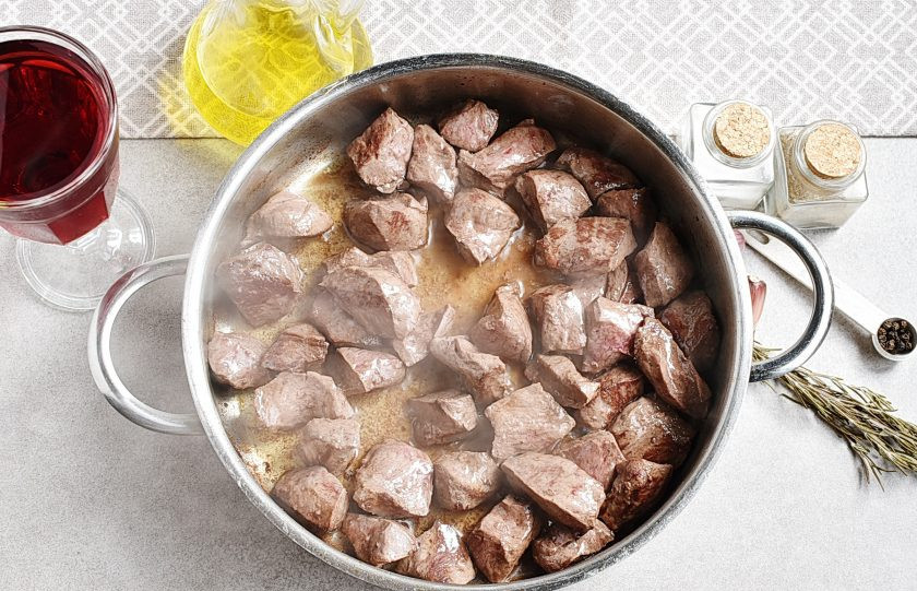 1. Этап. Мясо в вине: Обжарьте партиями нарезанное кубиками мясо в хорошо прогретом сотейнике с маслом до румяной корочки.