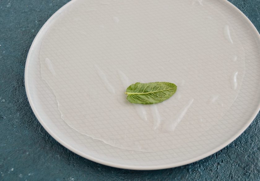 1. Этап. Весенние роллы: Окуните лист рисовой бумаги в горячую воду. На один край положите листочек мяты.