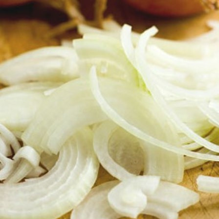 1. Этап. Мясо по-южному: 4. Луковицу очистить и нарезать полукольцами. Чеснок почистить и выдавить через пресс. Отправить овощи на сковороду и жарить до золотистого цвета.