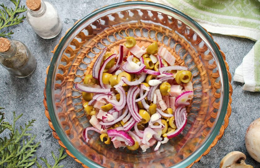 1. Этап. Салат Гречанка: Красный лук тонко порежьте и добавьте в салатник.