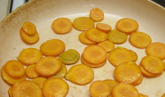 1. Этап. Салат с цукини: 1. Морковь помойте и очистите. Нарежьте тонкими слайсами. В сковородке разогрейте масло и обжарьте в нем кружочки моркови. После чего переложите в тарелку.