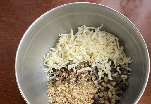 1. Этап. Террин из индейки с грибной начинкой: К грибной массе добавьте натертый на крупной терке моцареллу и измельченные грецкие орехи. Посолите и поперчите по вкусу. Массу хорошо перемешайте.