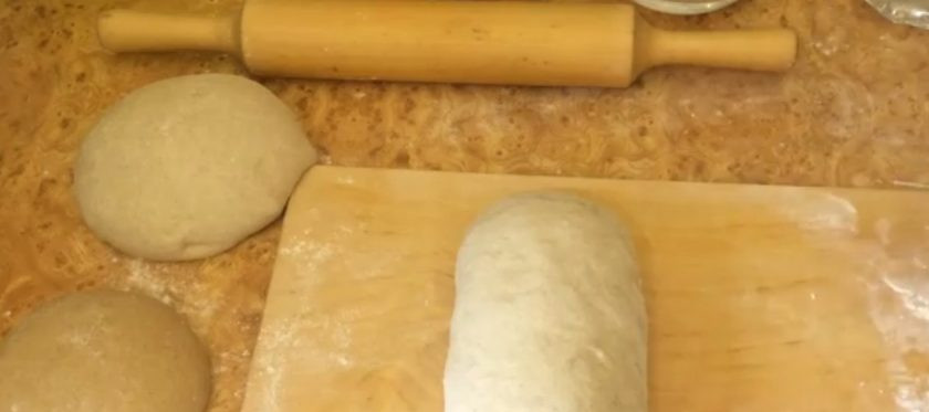 1. Этап. Хлеб Полярный простой: 5. Раскатайте темное тесто и выложите его на светлое. Сверните в плотный рулет, скрепите концы и присыпьте булку мукой. Выложите заготовку в прямоугольную форму, утрамбуйте, накройте пленкой и оставьте при комнатной температуре на 1 час.