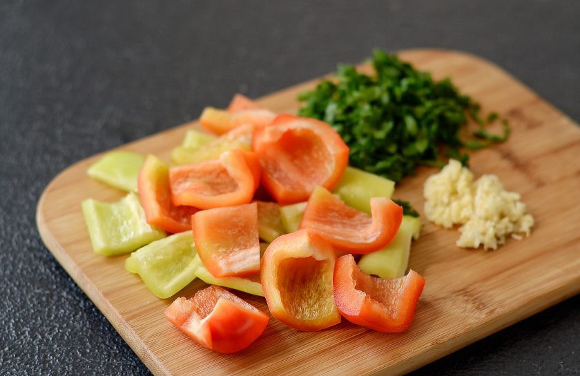 1. Этап. Перец по-грузински: Перец помойте, очистите от семян, удалите хвостик. Нарежьте крупными ломтиками. Чеснок пропустите через пресс, зелень мелко порубите.