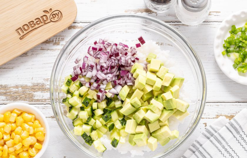1. Этап. Салат с рисом, кукурузой и майонезом: Огурец, авокадо и красный лук нарежьте на маленькие кубики. Добавьте к рису.