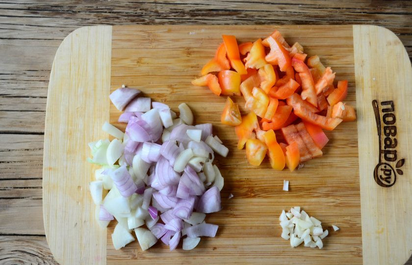 1. Этап. Салат из помидоров и кабачков на зиму: Крупным кубиком нарежьте лук, примерно такими же кусочками порежьте и сладкий перец. Чеснок можно пропустить через пресс, но как по мне, то лучше просто мелко нарезать ножом.