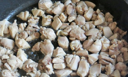 1. Этап. Капуста, тушенная с курицей и помидорами: Мясо обрезаем с косточки и нарезаем небольшими кусочками, обжариваем его на сковороде с ложкой растительного масла.