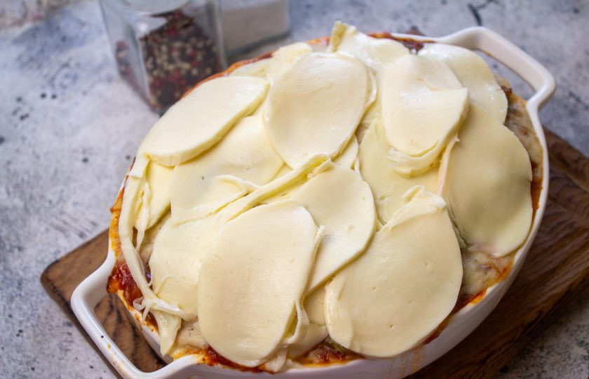 1. Этап. Запеканка из баклажанов по-гречески: Достаньте запеканку из духовки, выложите сыр и запекайте еще 10 минут.