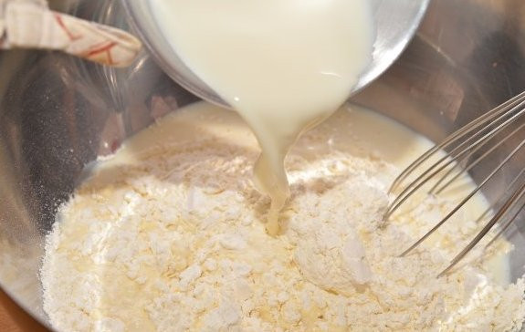 1. Этап. Сдобные пирожки с творогом: Молоко так же нагреваем и добавляем к нему половину от всей муки, перемешиваем.