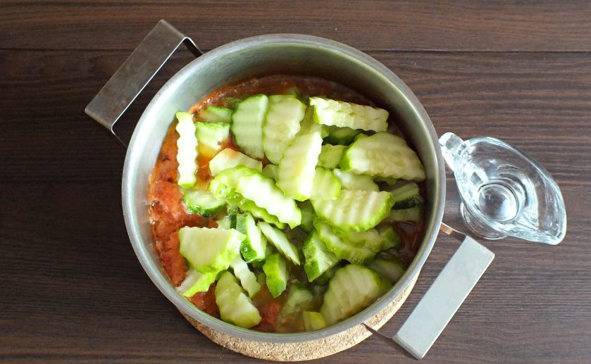 1. Этап. Салат Зимняя сказка на зиму: По истечении времени добавьте в кипящую овощную массу нарезанные огурцы и уксус. Верните на огонь и проварите с момента закипания 5 минут.