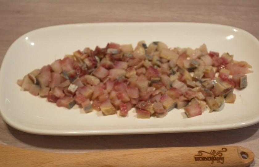 1. Этап. Салат Лисий хвост: Сельдь очистите от шкурки и костей. Филе нарежьте мелким кубиком. Выложите на тарелку. Лучше брать плоскую широкую и прямоугольную тарелку, чтоб было, где 