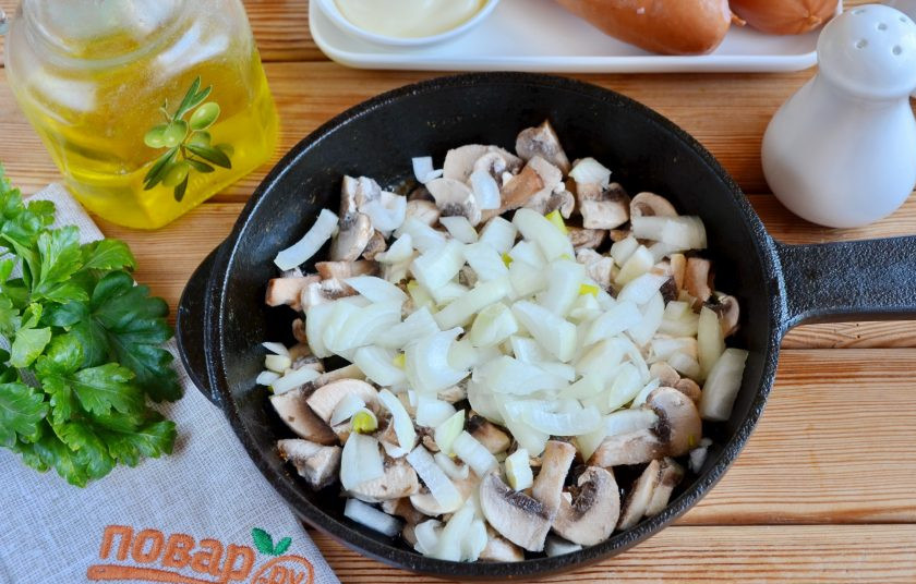 1. Этап. Сардельки, фаршированные сыром и грибами: Грибы с луком и растительным маслом обжарьте до готовности, посолите и поперчите по вкусу, но учитывайте, что сардельки тоже соленые.