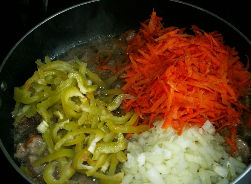 1. Этап. Капуста, тушенная с мясом и грибами: 2. Спустя указанное время добавим перец, лук и морковку. Обжарим все вместе еще 5-6 минут, а затем закладываем нашинкованную капусту и грибы. Солим по вкусу, тушим 25 минут, пока капуста не осядет.