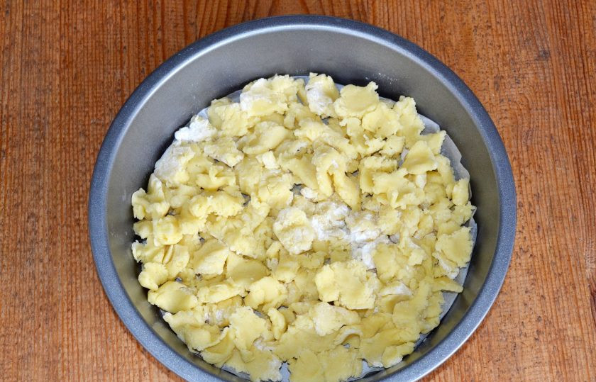 1. Этап. Торт Чебурашка: Жаропрочную форму застелите пергаментом. Выложите на дно половину песочной крошки.