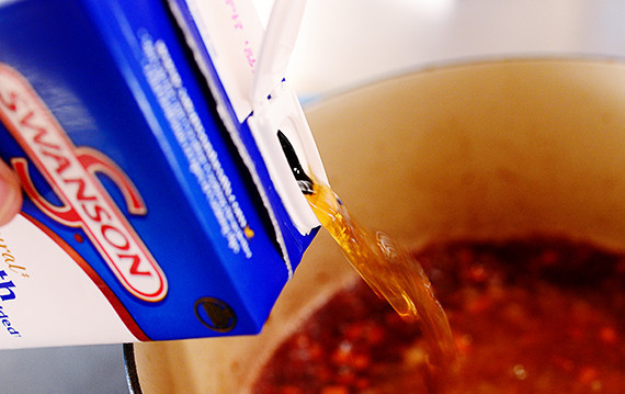 1. Этап. Сэндвичи с ребрышками: Долейте бульон и верните ребра в сковороду.