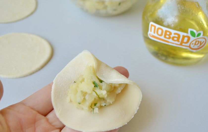 1. Этап. Курзе с картошкой: 10. Возьмите кружочек теста с картошкой в руки, так удобнее лепить. Заверните край теста на картошку, как на фото.