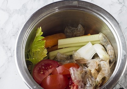 1. Этап. Рис с морепродуктами: Очистим креветки от голов и панциря, сложим очистки в кастрюлю. Добавим очищенную морковь, одну луковицу, помидор и стебель сельдерея. Заливаем все 1,2 л воды и варим минут 40.