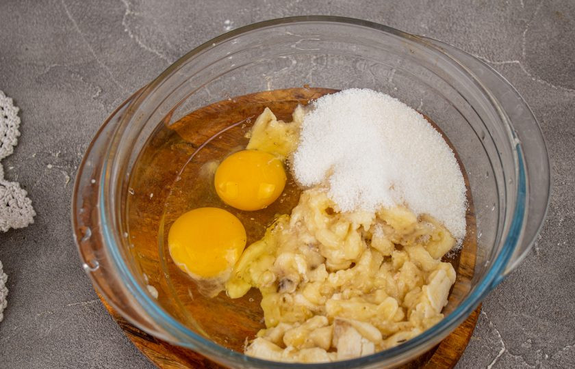 1. Этап. Шоколадно-банановый пирог Брауни: К банановому пюре добавьте яйца, сахар и ванильный сахар. Перемешайте венчиком.