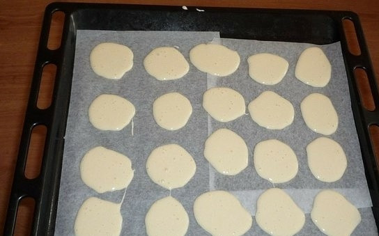 1. Этап. Торт Черепаха со сметанным кремом: Взбейте яйца с сахаром, добавьте муку и соду. Тесто должно получиться жидким. Застелите пергаментом противень для запекания и ложкой вылейте на него тесто так, чтобы получились кружочки.