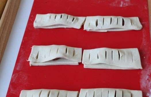 1. Этап. Слойки с вареньем: Закрываем начинку той частью, на которой есть надрезы и тщательно защипываем края. Выкладываем слойки на противень, застеленный пергаментной бумагой и смазываем верх каждой слойки взбитым яйцом. Выпекаем в разогретой до 200 градусов духовке примерно 20 минут. Остывшие слойки посыпаем сахарной пудрой.