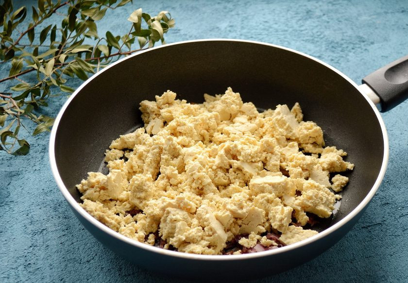 1. Этап. Скрэмбл из тофу: Сверху руками покрошите тофу. Обжаривайте его на сковороде 3 минуты.