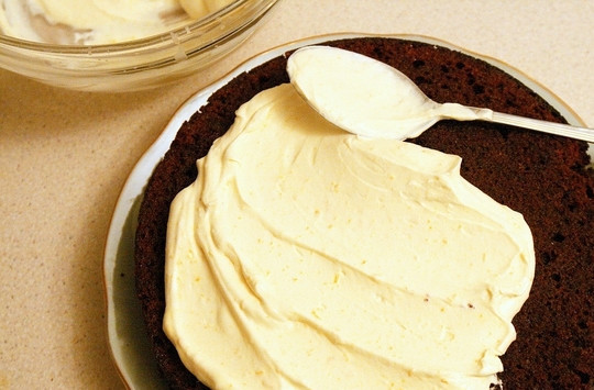 1. Этап. Бисквит с творожным кремом: Готовому бисквитному коржу дайте остыть, разрежьте его по возможности на две-три части. Пропитайте коржи чуть-чуть ликером или любимым сиропом. Сверху равномерно нанесите крем.