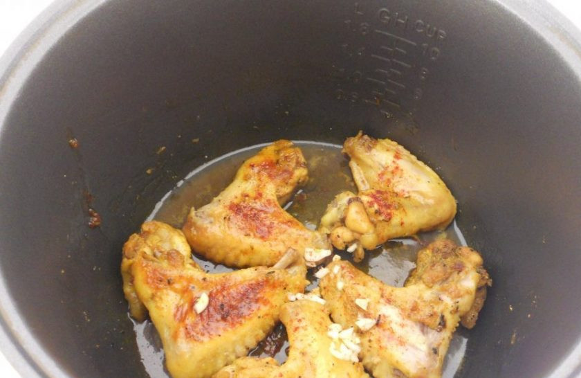 1. Этап. Курица в мультиварке: Через 30 минут крылышки переверните. Затем посыпьте их перцем чили и измельчённым чесноком. Оставьте уже без режима на 10 минут в мультиварке.
