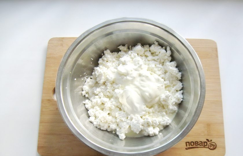 1. Этап. Творожный десерт Старая Рига: Выложите сметану в миску с творогом и сгущенным молоком.