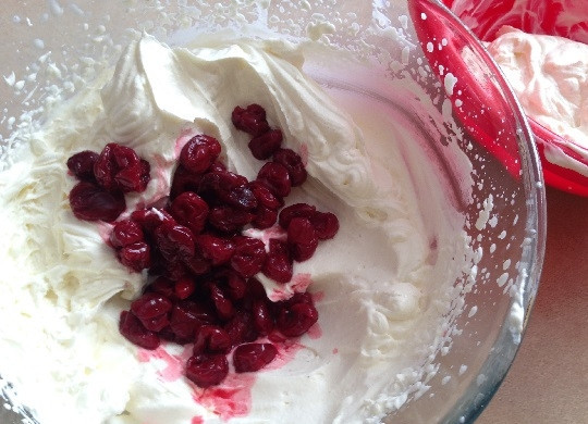 1. Этап. Бисквитный торт с вишней и творожным кремом: 11. Треть крема откладываем в отдельную миску, а в оставшийся добавим вишню и размешаем.