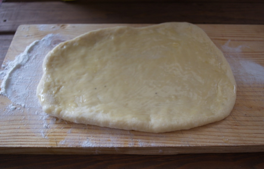 1. Этап. Сладкие булочки на кефире: На присыпанной мукой поверхности раскатайте часть теста в пласт. Смажьте растопленным сливочным маслом. Посыпьте сахаром (1 ст. ложка).