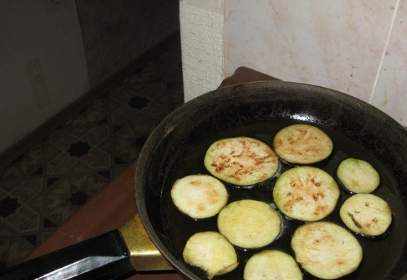 1. Этап. Баклажаны острые на зиму без стерилизации: Обжарьте баклажаны в растительном масле с обеих сторон до золотистого цвета.