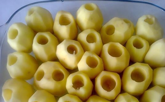 1. Этап. Картофель, фаршированный фаршем: 1. Картофель промойте, очистите. Желательно, чтобы картофелины были примерно одинаковой формы. Вырежьте серединку. Противопригарный противень смажьте растительным маслом и выложите в него картошку отверстием вверх.