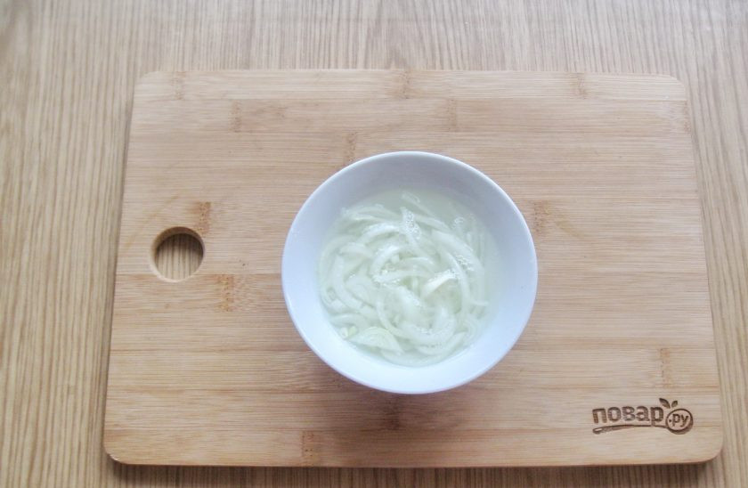 1. Этап. Салат с ветчиной и маринованными грибами: Репчатый лук очистите, помойте и нарежьте. Выложите в мисочку и залейте кипящей водой. Через 5-7 минут воду слейте.