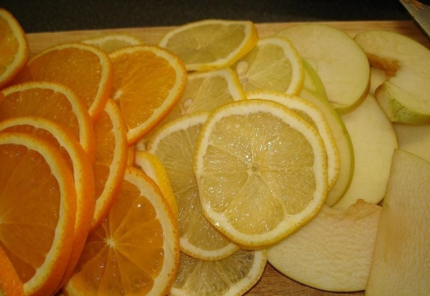 1. Этап. Пунш безалкогольный: 1. Поскольку все фрукты использую вместе с кожурой, то очень хорошо мою их в проточной воде, а затем обдаю кипятком. Яблоко нарезаю на дольки и вычищаю семечки, а лимон и апельсин нарезаю кружочками.