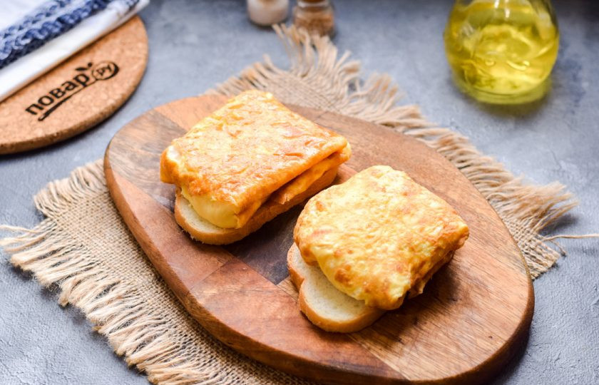 1. Этап. Рецепт завтрака из яиц: После сверните блинчик еще один раз, чтобы получился квадрат или прямоугольник. Также поджарьте и начините сыром вторую половину яиц. Переложите готовые яичные конвертики на ломтики свежего батона.